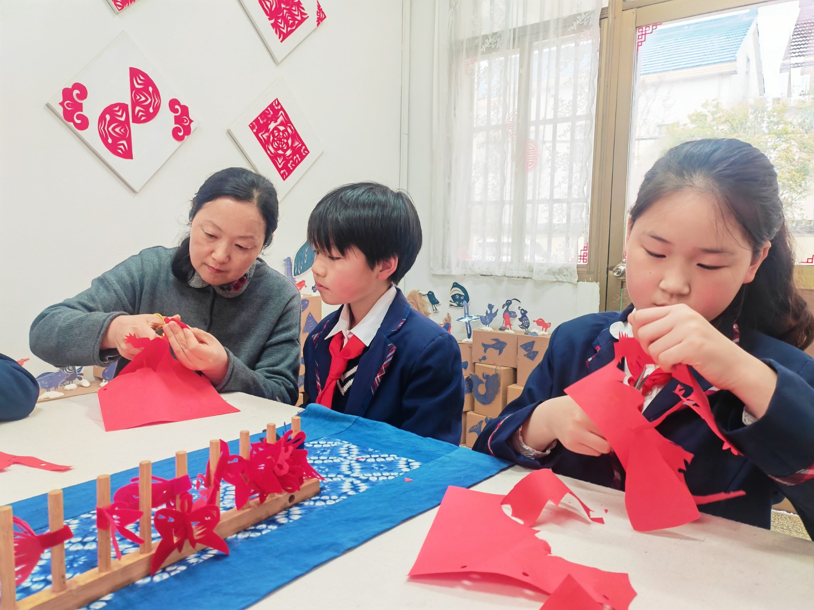4月19日 星期日 （二版） 近日，九总小学的剪纸社团室内，新一轮主题活动又开始了。孩子们在指导老师的带领下，以身边的春景为元素，创作专属于春天的剪纸作品。全媒体记者 刘蕾 张亦徐 摄.jpg
